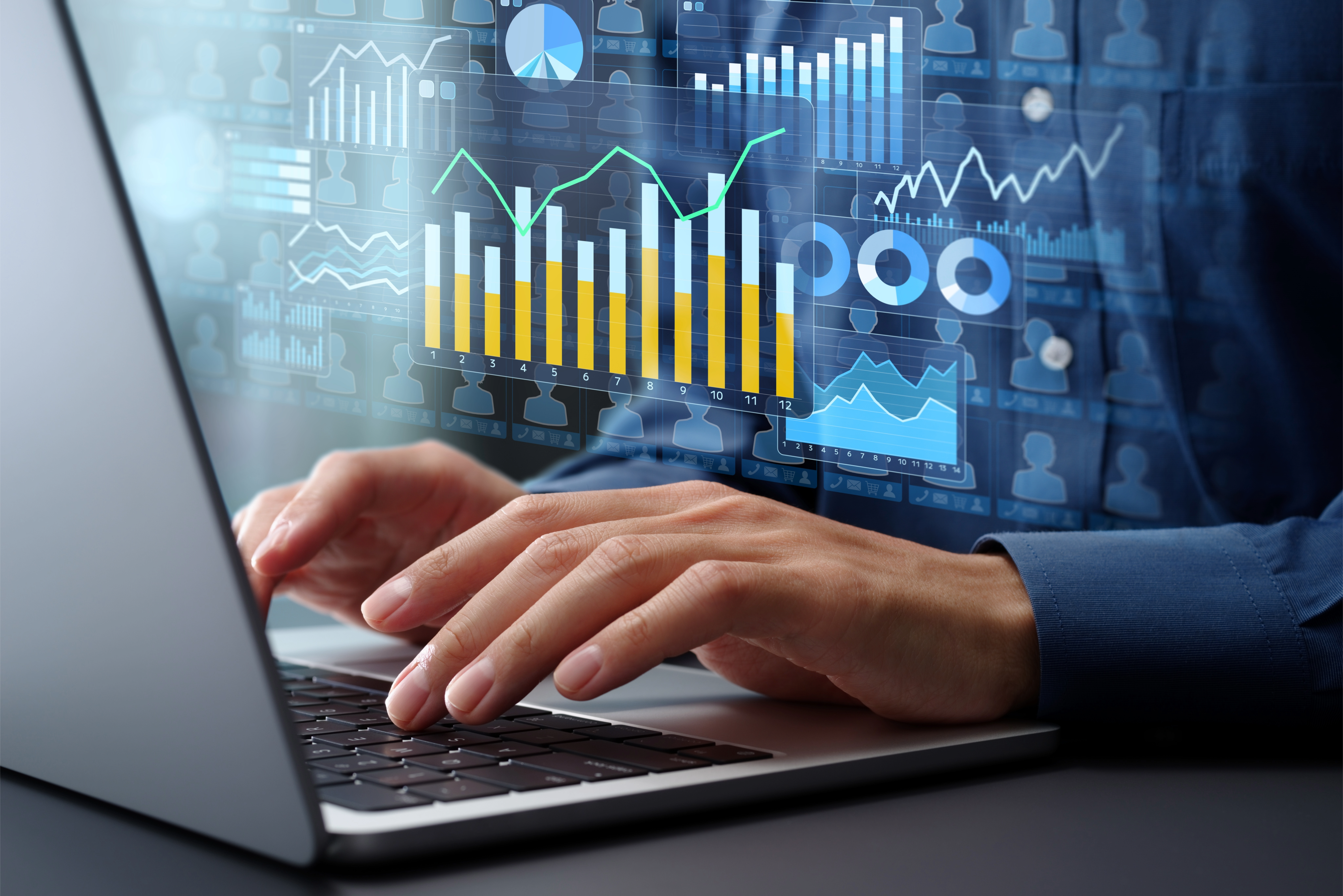Person typing at a keyboard with charts surrounding the hands.