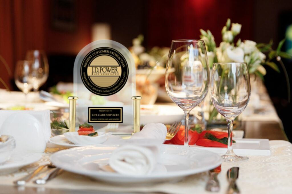 A close-up of a table with elegant tableware set out and a trophy of a J.D. Power award at an awards venue.